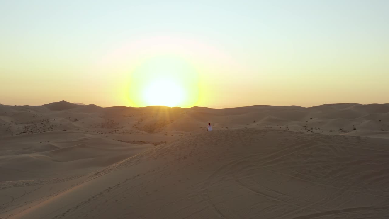 feliz mañana duna de arena amanecer mujer sentada en un montículo abrazando los rayos del sol