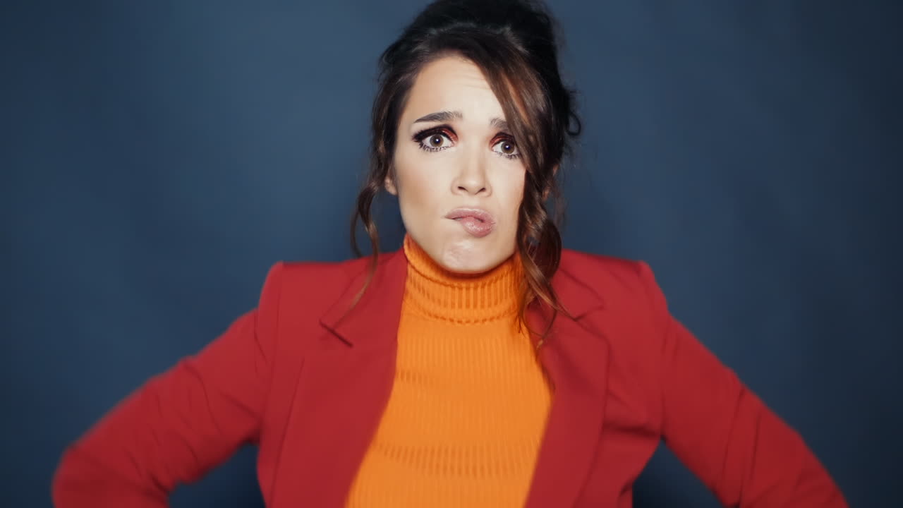 어두운 배경에 서 있는 사려 깊은 긴장 한 여자. 세련된 옷을 입은 소녀