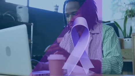 animation of blue ribbon icon over african american man drinking coffee and using laptop at a cafe