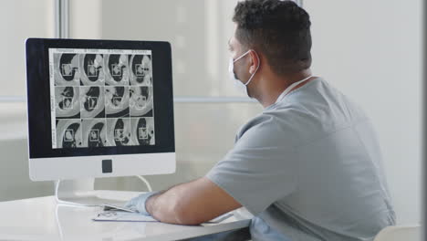 médico examinando la tomografía computarizada en la computadora en el consultorio médico