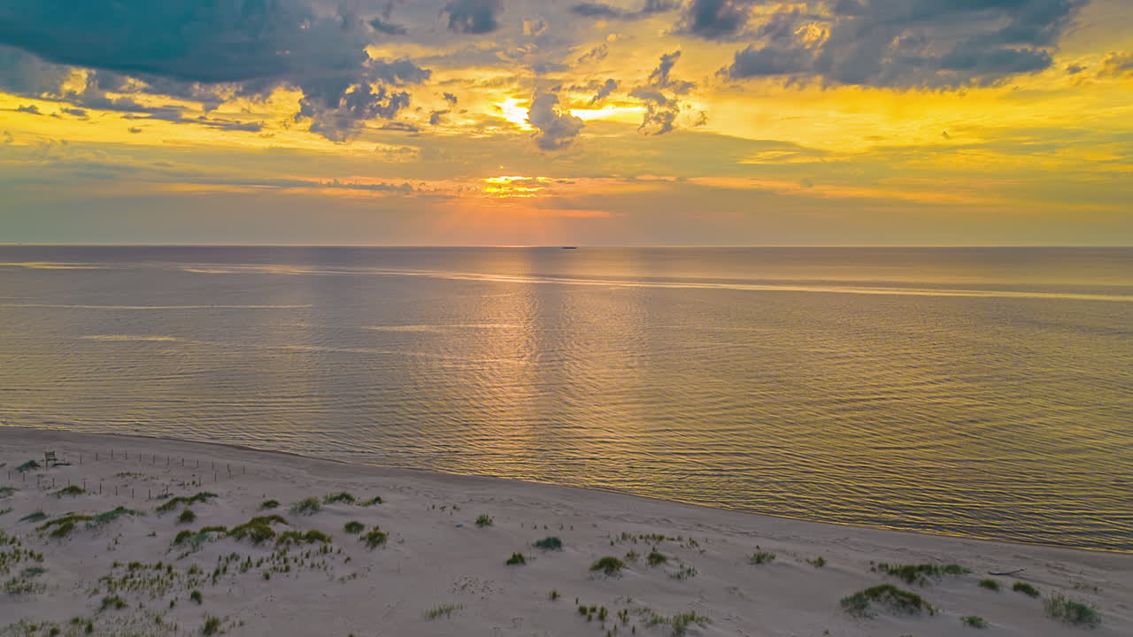 la luz dorada del sol detrás de las nubes iluminada sobre el idílico paisaje marítimo durante la puesta de sol