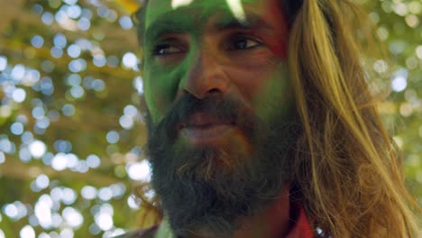 indian man close-up of face smeared with bright holi colors