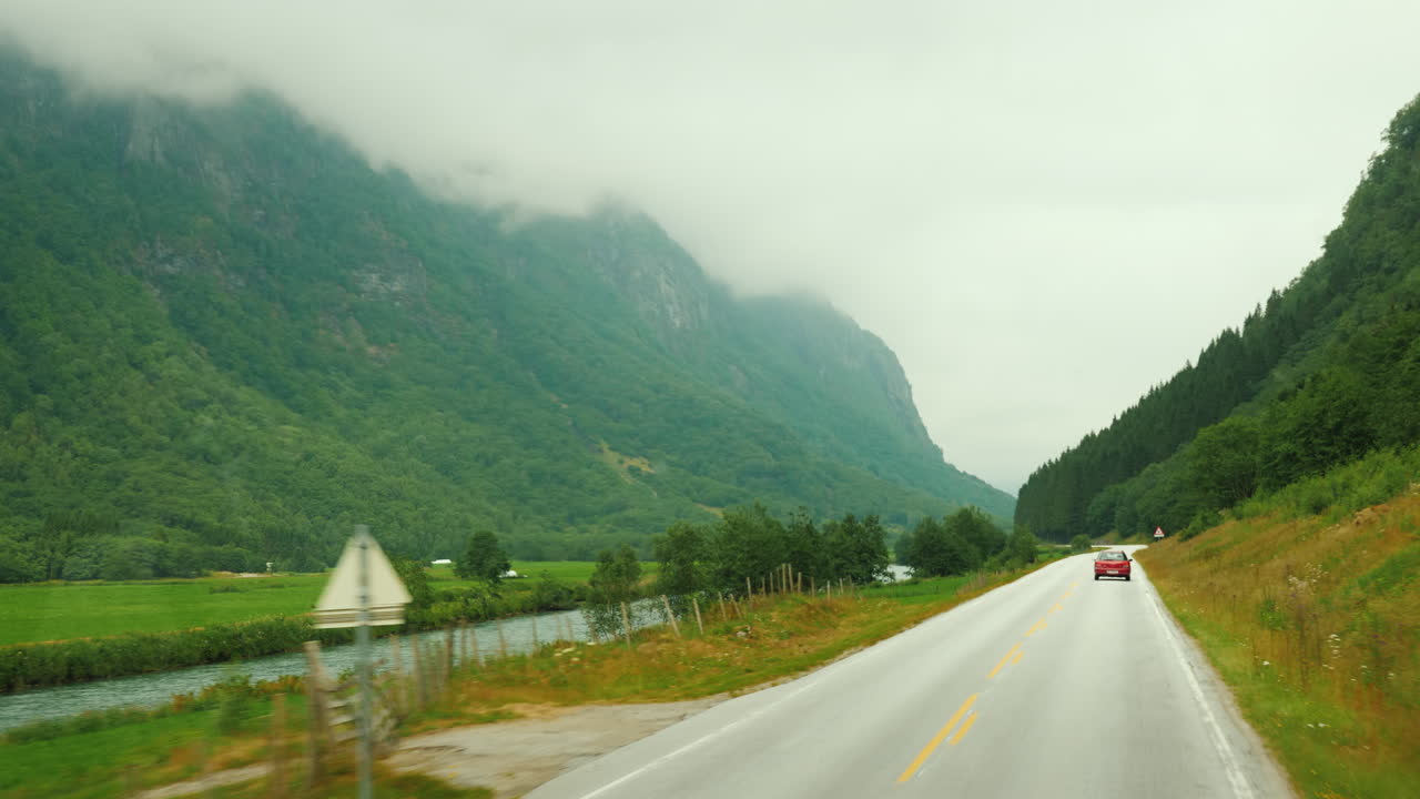 노르웨이 1인칭 시점의 산들 사이의 경치 좋은 길을 따라 가다