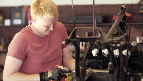 Medium Close Up of Young Blonde Man Using Power Tools During Motorcycle Teardown