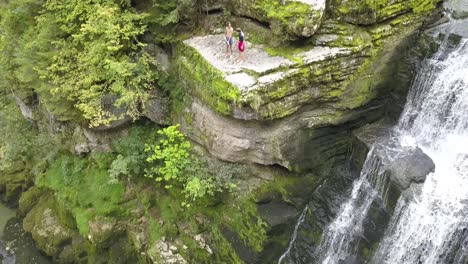 Tilt-down,-waterfall-and-rocks,-people-want-to-jump,-Doubs-river,-Neuchâtel,-Switzerland