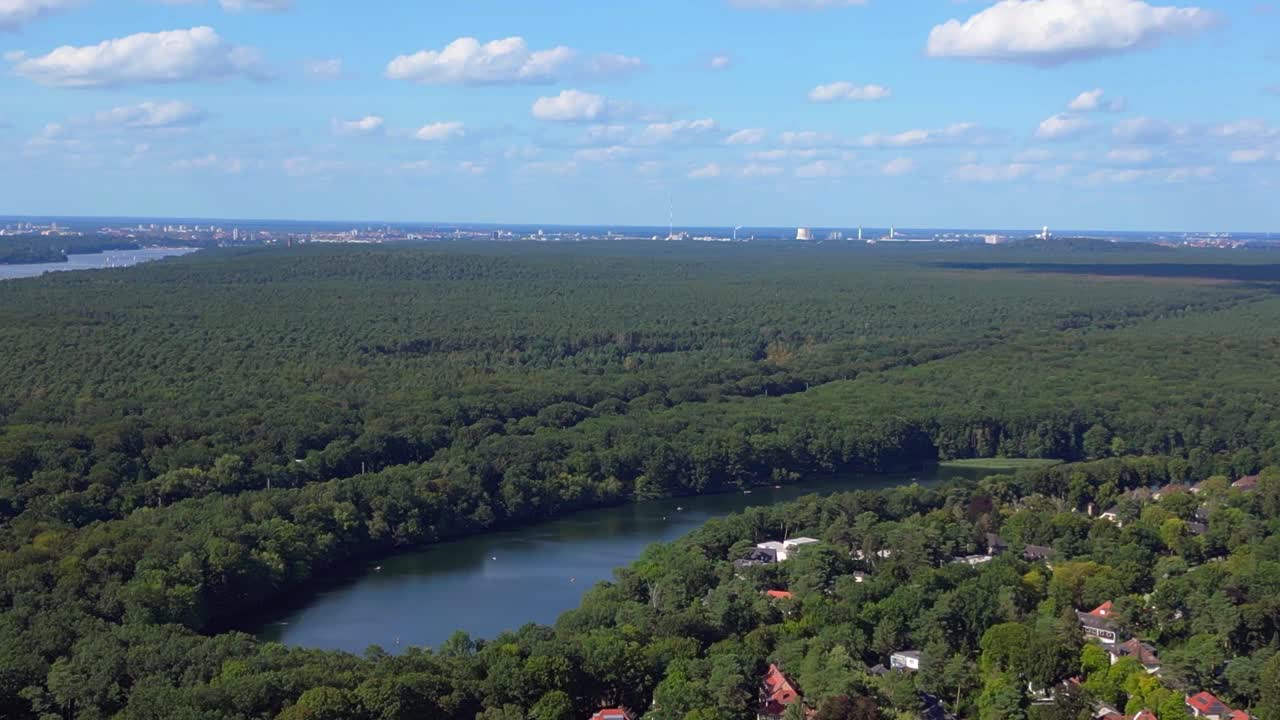 Wannsee lakes surrounded by lush green forest on sunny day with blue sky and clouds. Majestic aerial view flight panorama overview drone