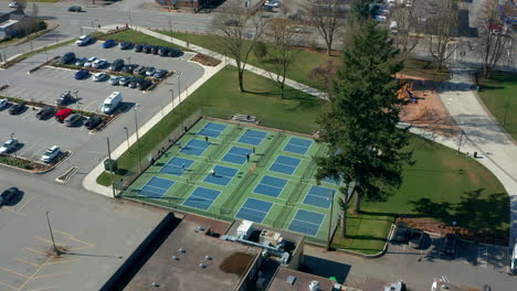 tennis players in a city park, drone dolly in over the sports courts