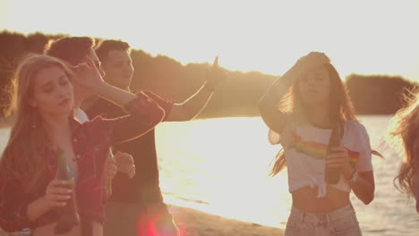 Teenagers-celebrate-a-birthday-on-the-beach-party-with-beer-and-good-mood.-This-is-carefree-summer-evening-at-sunset.