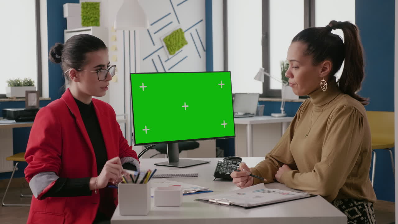 Business women doing teamwork on computer with green screen