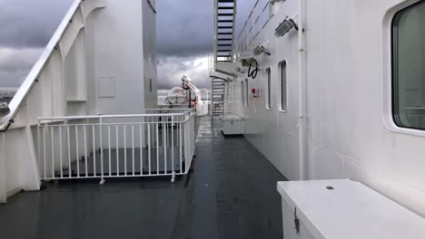 walking on a wet dark deck on a ferry sailing between vancouver and salt spring island