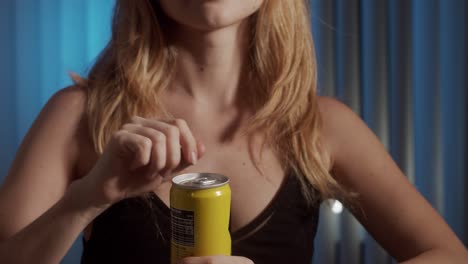 girl is opening a can with juice drink