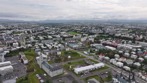 Vista-Aérea-De-Los-Edificios,-Iglesias-Y-Parques-De-Los-Suburbios-Residenciales-De-Reykjavik-Islandia