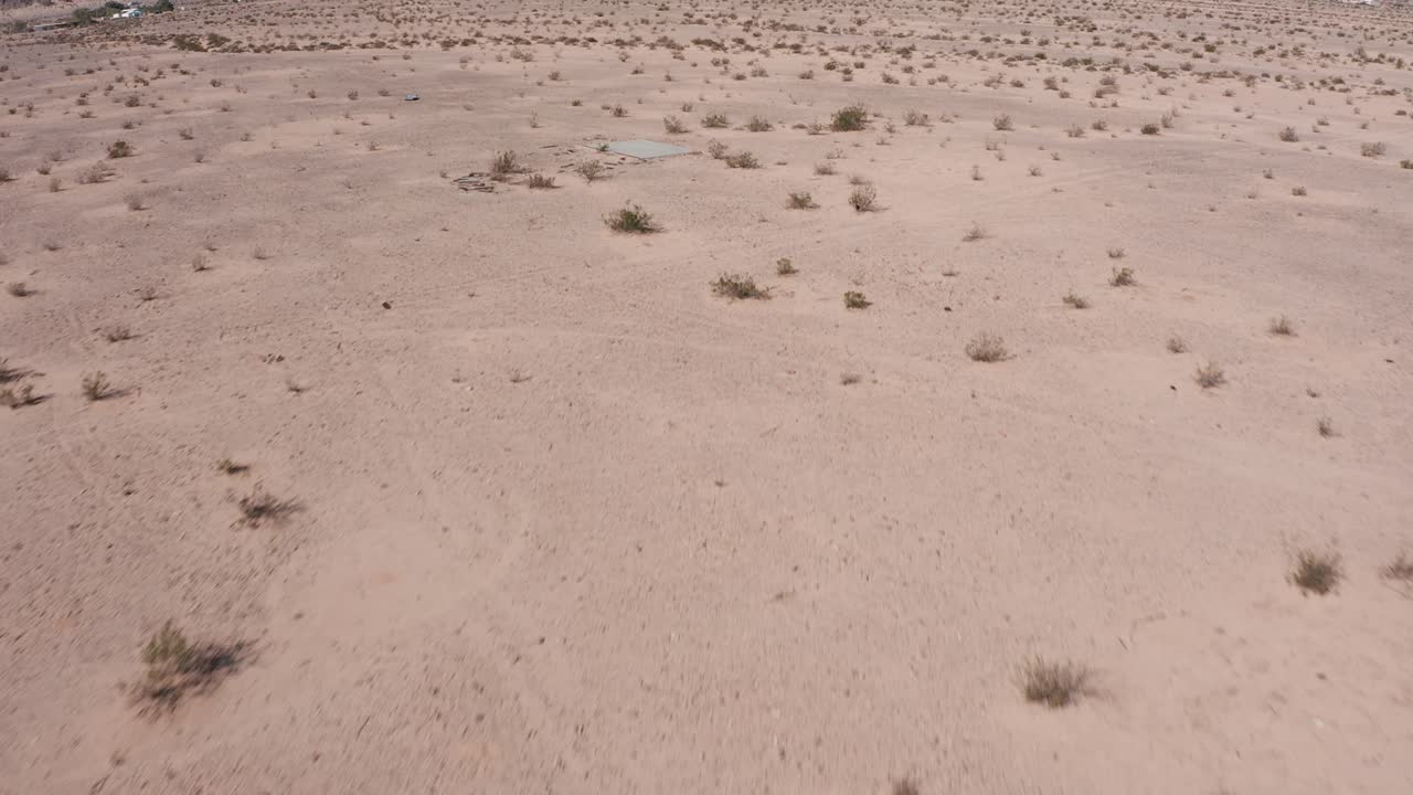 희박한 사막 위로 날고 캘리포니아의 산까지 기울어지는 낮은 공중 샷