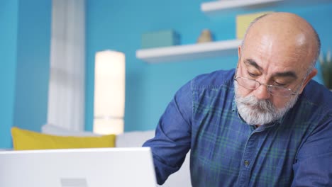 retired old man is using laptop. technology inexperience.