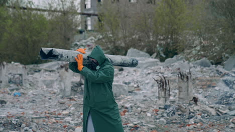 person in gas mask on ruins. man in protective clothing and gas mask walking through the ruined city
