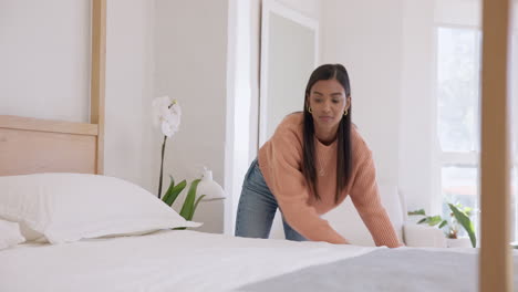 Woman,-making-up-bed-and-chore-in-bedroom