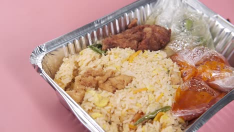 fried rice with chicken and sauce in takeout container