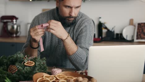 Hombre-Mirando-Una-Guía-En-Línea-Sobre-Cómo-Hacer-Adornos-Navideños.