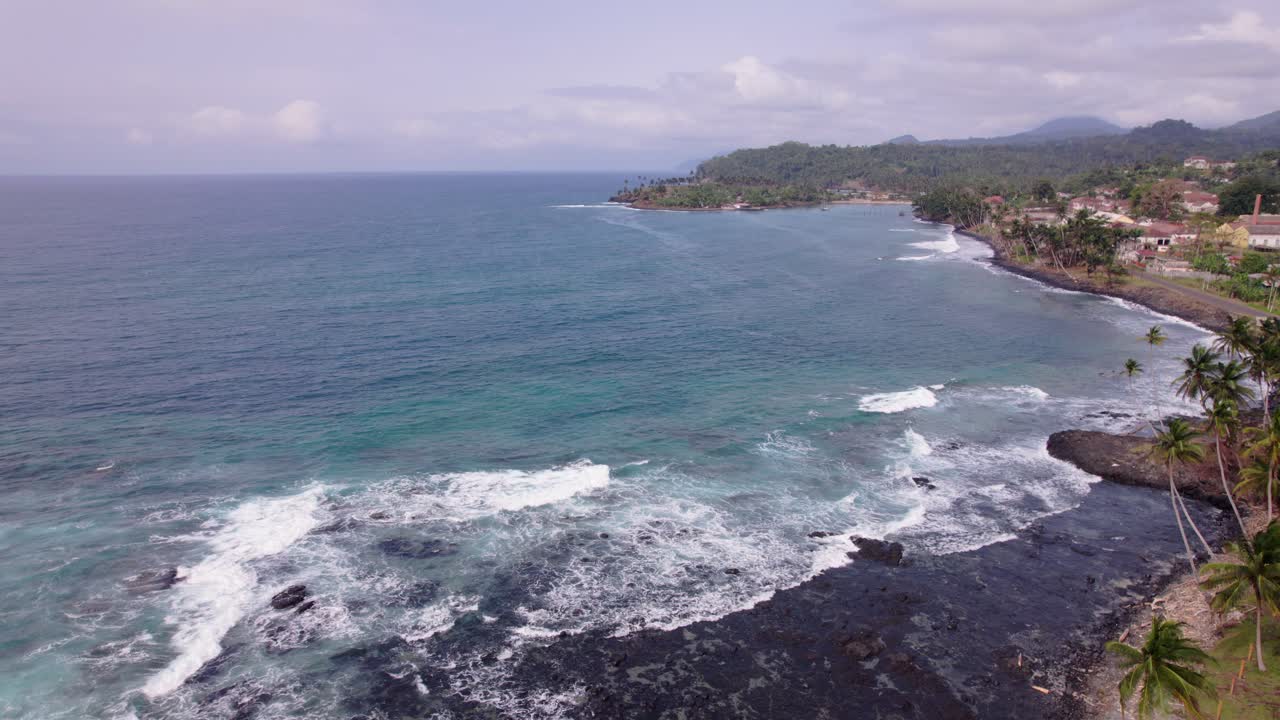 Praia tropical paradisíaca com palmeiras e rochas vulcânicas em São Tomé