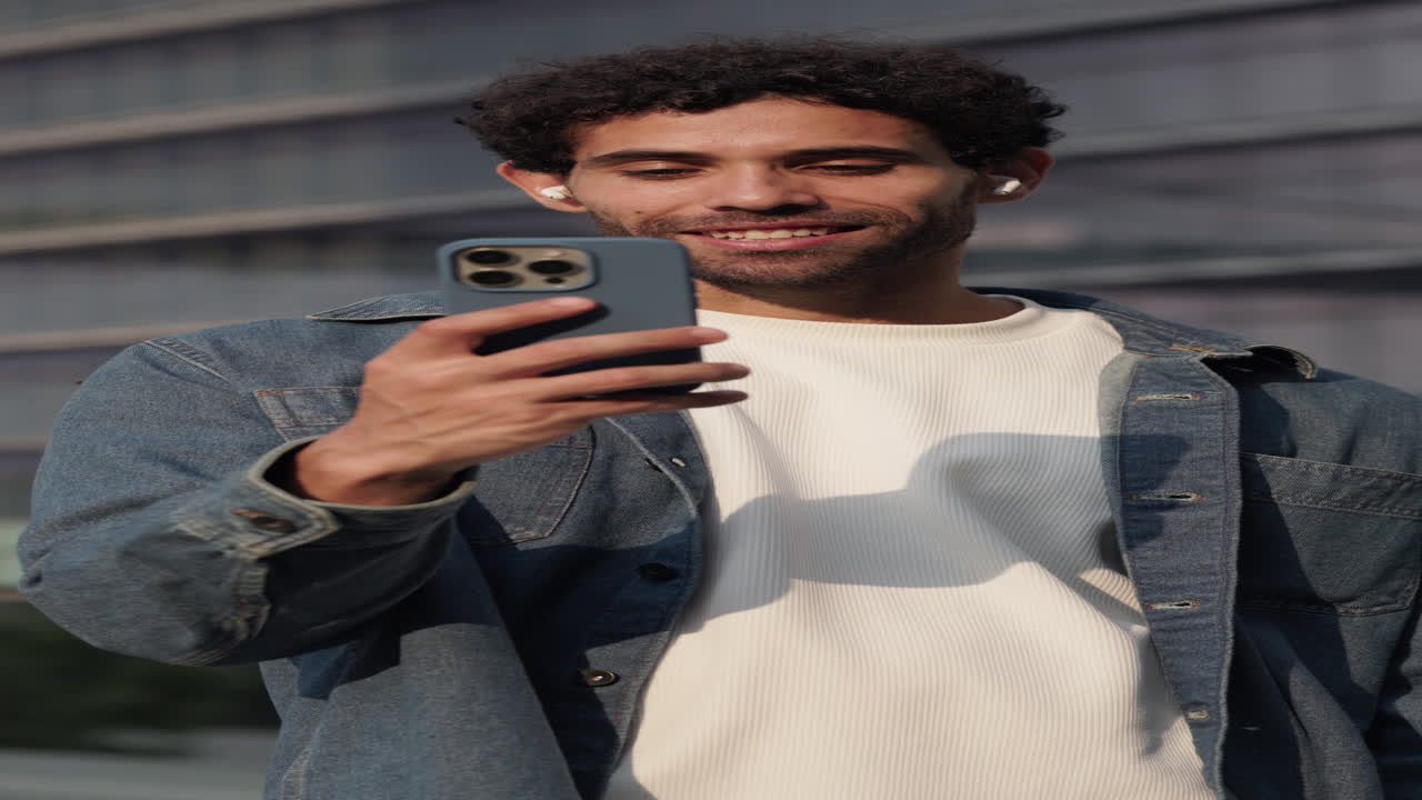 Giovane uomo felice che registra un video o scatta un selfie all'aperto