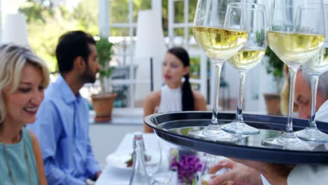 waiter serving glasses of wine to customer