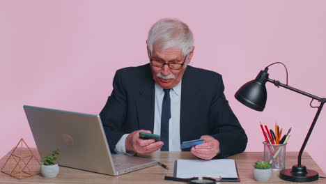 senior businessman using credit bank card and smartphone while transferring money, purchases online