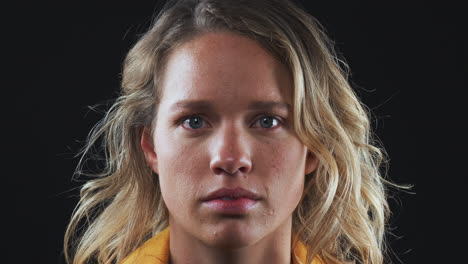 head and shoulders studio shot of unhappy woman looking at camera with sad expression in slow motion