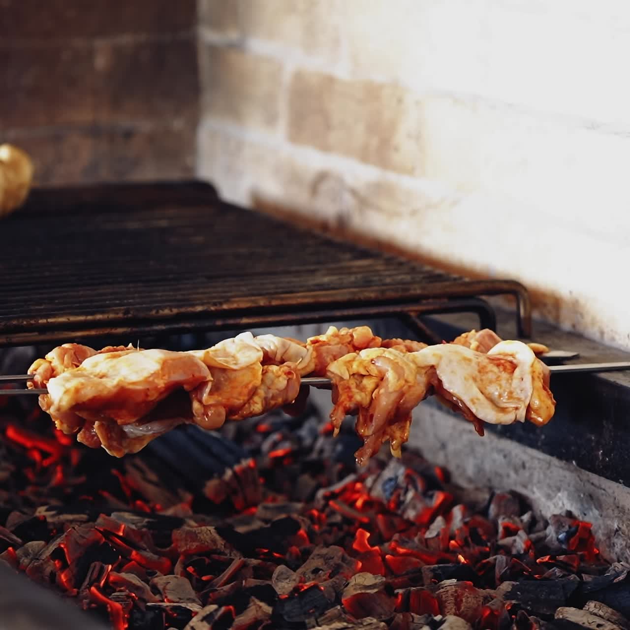 Cooking mushrooms on grill. Cook puts some skewers with chicken meat on charcoal. Preparing the barbeque on the restaurant kitchen.