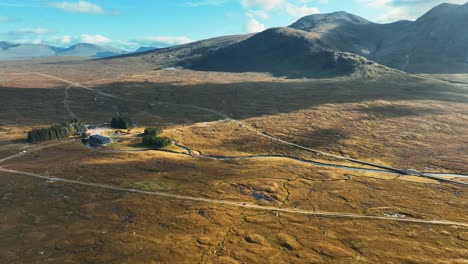 Drone-shot-flying-over-beautiful-valley-in-rural-Scottish-Highlands,-Scotland-viewing-the-moorland-landscape-of-Glencoe