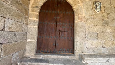 ancient wooden church door in stone wall