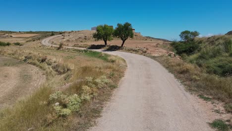camino de tierra llegando a los edificios en ruinas en teruel, aragón