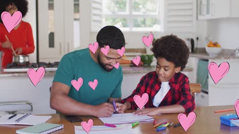 Animation-of-social-media-heart-icons-over-smiling-biracial-man-and-son-doing-homework