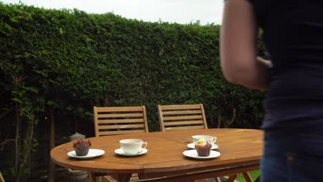 tea and muffins in the garden white china tea cups and saucers on wooden table buns