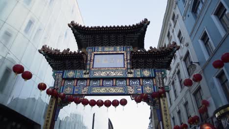 gate and red lanterns in china town area in london uk in slow motion