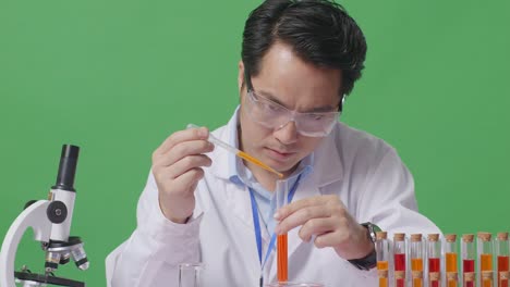 Close Up Of Asian Man Scientist Making Experiment With Test Tube And Saying Wow While Working On The Table With Microscope In The Green Screen Background Laboratory