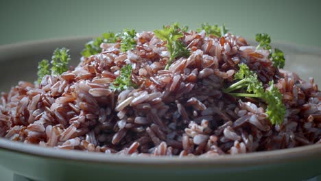 brown rice with parsley on top turning on plate