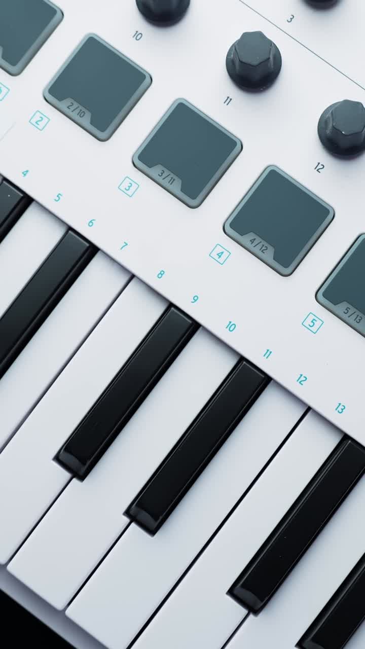 Plan macro vertical d'un contrôleur clavier MIDI avec pads de batterie et potentiomètres, idéal pour la production musicale, le flux de travail en home studio et la création sonore.