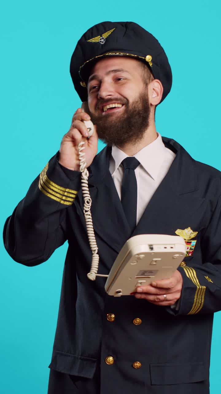 Video verticale: pilota commerciale che parla al telefono fisso in studio
