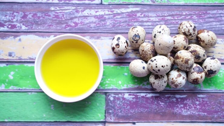 Quail Eggs and Oil on a Colorful Wooden Background