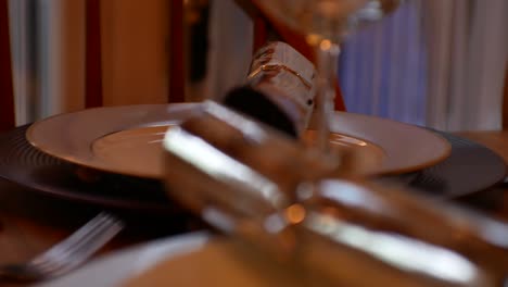 Christmas-dining-room-close-up-table-setting-crackers-on-dinner-plates-rack-focus-front-to-rear