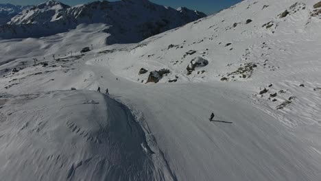 aerial shot following a skier skiing down a mountain in the french alps