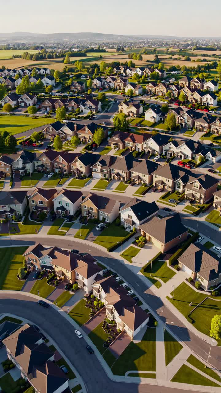Aerial video view of modern suburban homes with manicured gardens and pathways, showcasing elegant