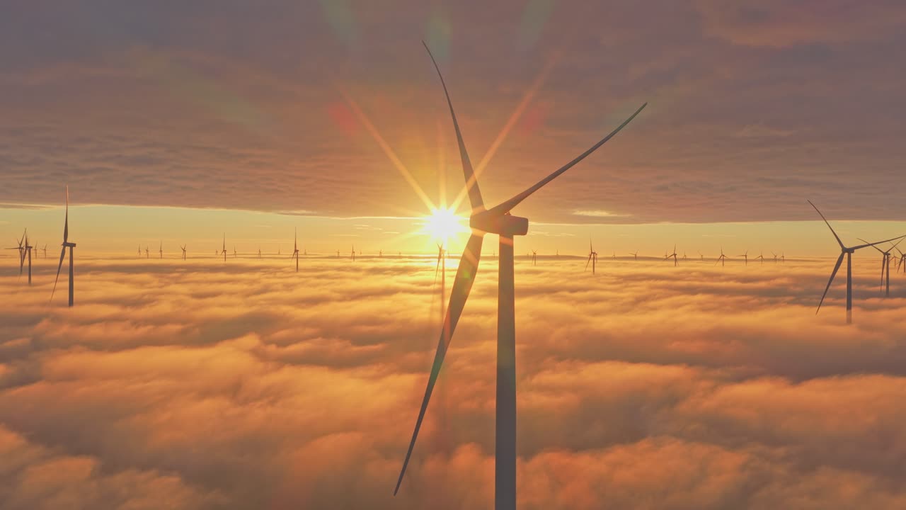 Windpark am Afsluitdijk, im Sonnenaufgang unter treibenden tiefhängenden Wolken leuchtend