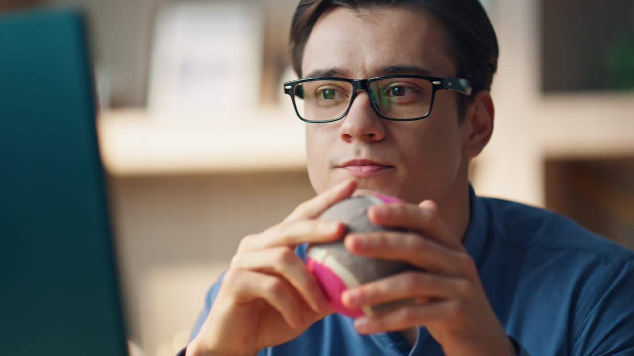 un hombre de negocios en primer plano mirando la pantalla de la computadora de la oficina. un tipo con una pelota examinando el proyecto.