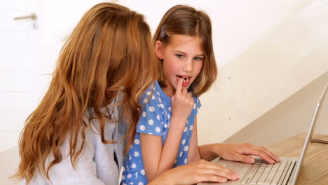 Una-Niña-Usando-Una-Computadora-Portátil-Con-Su-Madre-En-La-Mesa