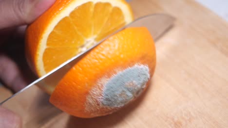 cutting an orange with mold