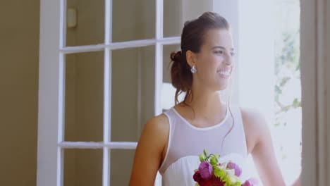 Bride-standing-near-the-window-with-a-bouquet-4K-4k