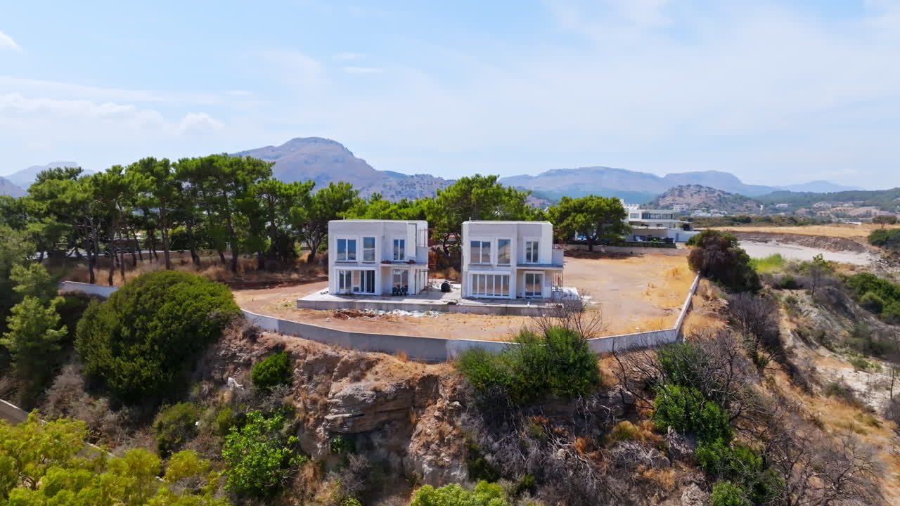 Panoramic drone shot orbiting holiday homes under construction, in sunny Greece