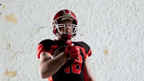 Animation-of-portrait-of-american-football-player-holding-ball-over-textured-white-background