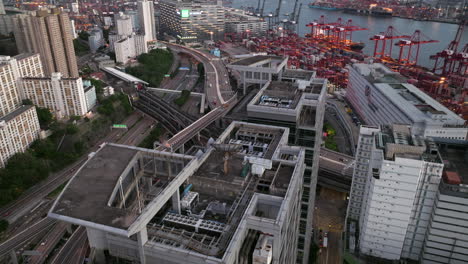 beautiful aerial establishing shot over mirrored high-rise revealing container shipping port and road network